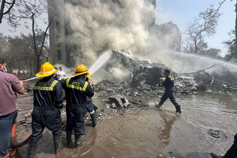 Firefighters work at the site of a plane crash in India's northwestern city of Ahmedabad