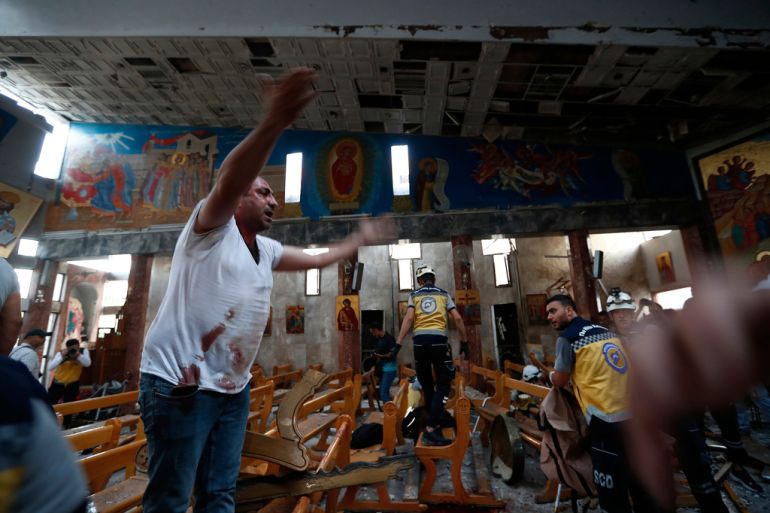 A Syrian man reacts inside Mar Elias church after attack