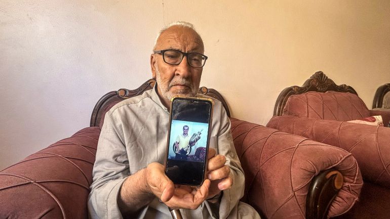 Mohammed Safi’s father, Shaker Safi, shows an image of his deceased son holding a football trophy. Mohammed, who was a junior football coach and umpire, was killed in an Israeli air strike in November 2023