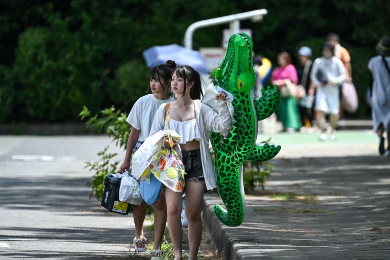 People leave the beachside area at Inage Seaside Park after much of coastal Japan went on tsunami alert following a 8.7 magnitude quake in the sea off eastern Russia, along Tokyo Bay in Chiba City, Chiba prefecture on July 30, 2025. [Philip Fong/AFP] (AFP)