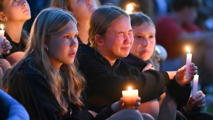 epa12328602 A child becomes emotional as they listen to speakers during a candle light vigil at a local park for the shooting at the Annunciation Catholic School in Minneapolis, Minnesota, USA, 27 August 2025. Two children were killed and 17 others wounded before the gunman took his own life. EPA/CRAIG LASSIG