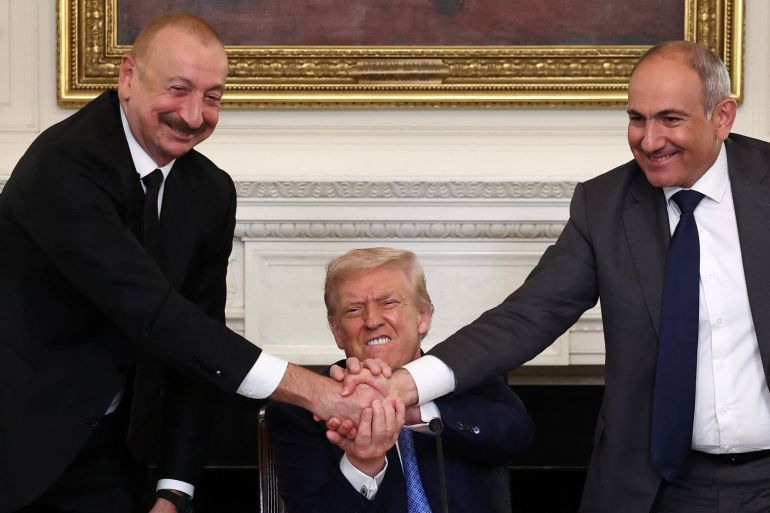 US President Donald Trump holds the hands of Azerbaijan's President Ilham Aliyev and Armenia's Prime Minister Nikol Pashinyan as they shake hands.