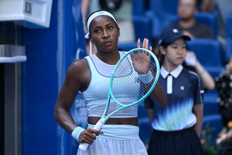 Coco Gauff reacts as she holds a tennis racquet.