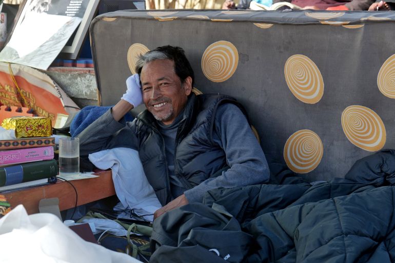 Sonam Wangchuk smiles as he rests his head on his hand.