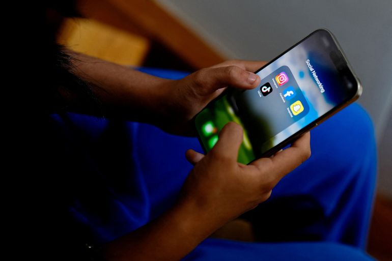 A high school student poses with her mobile showing her social media applications in Melbourne, Australia, November 28, 2024. REUTERS/Asanka Brendon Ratnayake