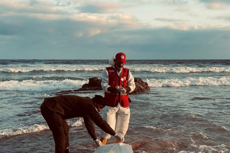 A member of the Red Crescent stands next to a body bag in a location given as near Surman, Libya, after a migrant boat capsized west of Libya's capital Tripoli,