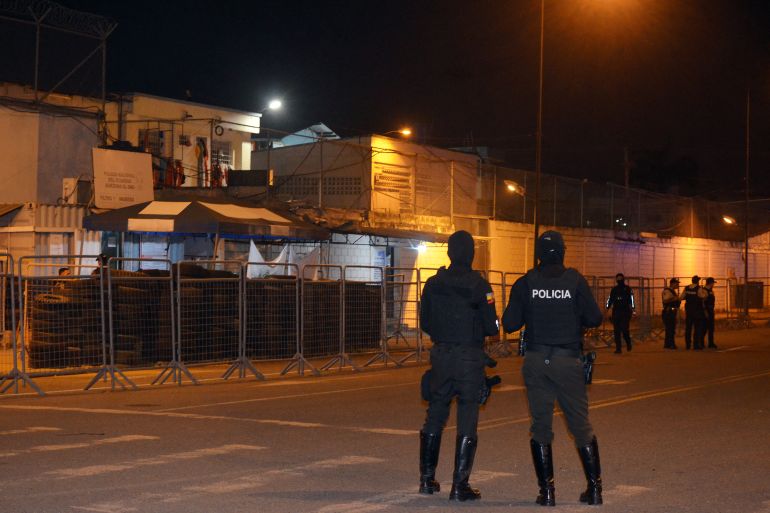 Police officers stand guard at the entrance to the Machala prison.