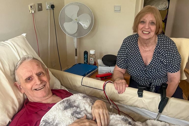 Linda and her husband, John, at the nursing home in 2023, where John was moved after Linda cared for her husband at home for nearly three decades [Courtesy of Linda]