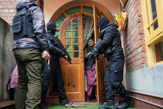 Jammu and Kashmir Special Operation Group (SOG) personnel question local residents during a house-to-house search operation as part of heightened security measures ahead of India's Republic Day in Srinagar
