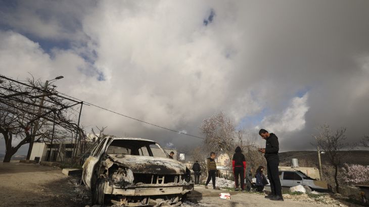 Palestinians check a charred car after it was allegedly set on fire by Israeli settlers in the village of Jalud, south of Nablus, in the occupied West Bank on January 30, 2023