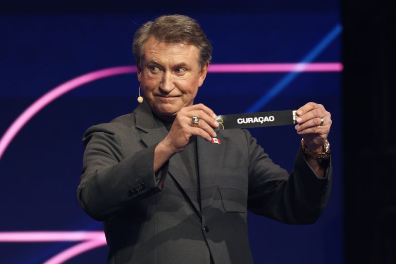 Former NHL player Wayne Gretzky displays Curacao during the draw for the 2026 soccer World Cup at the Kennedy Center in Washington, Friday, Dec. 5, 2025. (Dan Mullan/Pool Photo via AP)