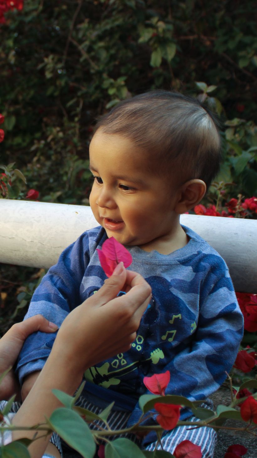 Smiling and laughing, Luisa plays with a red flower in front of her son Juan de Jesús’ damaged eye in the shelter’s garden, turning colour and motion into a shared game_-1773831298