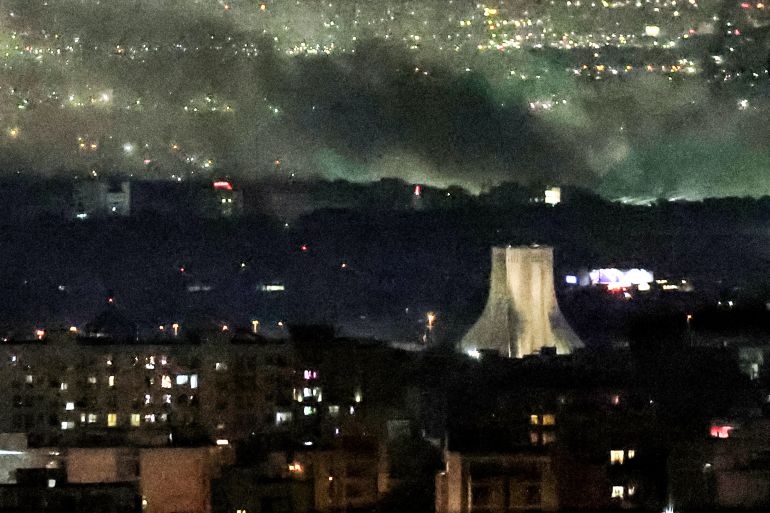 TOPSHOT - Smoke plumes billow from the site of airstrikes near Azadi Tower in western Tehran on March 10, 2026.