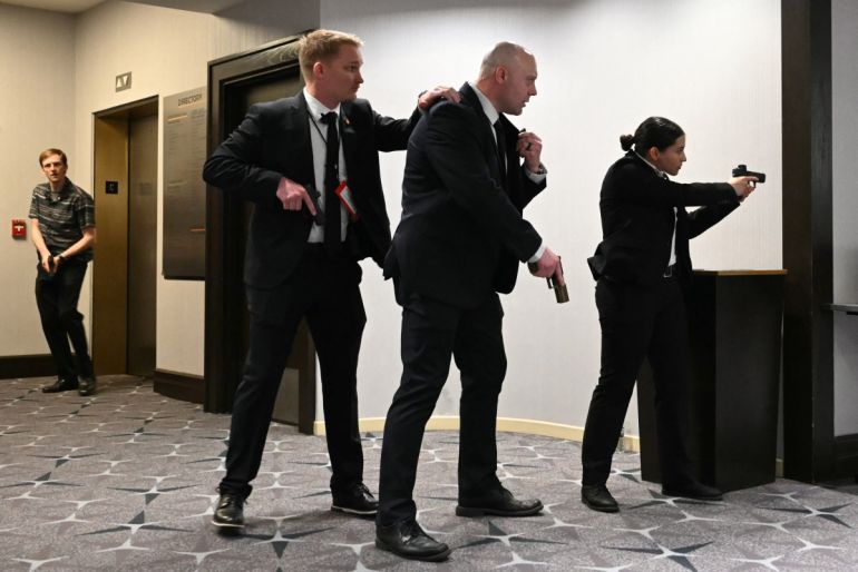Agents draw their guns at the Washington Hilton in Washington, DC, on April 25, 2026