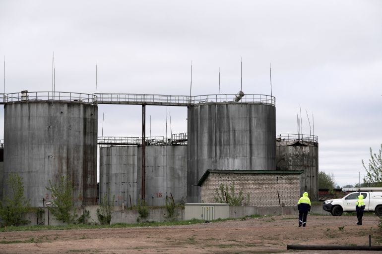 Police officers stand at the site of damage after drones crashed at a storage facility in Rezekne, Latvia, May 7, 2026. REUTERS/Janis Laizans