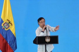 Gustavo Petro gives a speech next to a Colombian flag