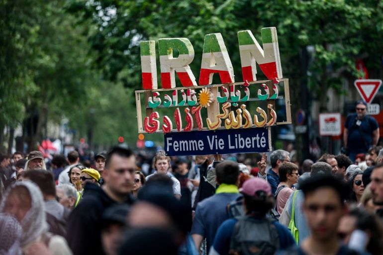 A protester holds a handmade sign with the letters forming the word Iran, during the traditional May Day labour union march in Paris, France, May 1, 2026. The slogan reads: "Woman, life, freedom". REUTERS/Benoit Tessier