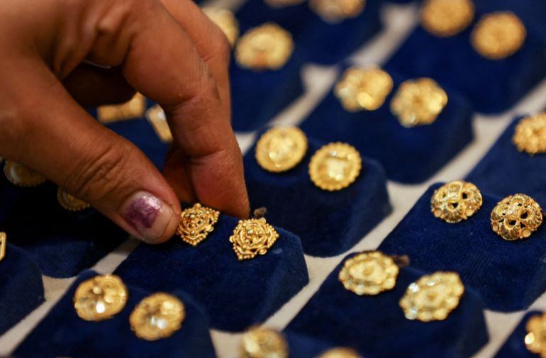 FILE PHOTO: A woman picks a gold earring at a jewellery shop in the old quarters of Delhi, India, May 24, 2023. REUTERS/Anushree Fadnavis/File Photo