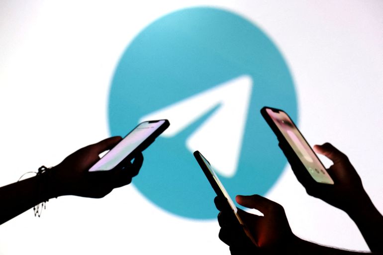 FILE PHOTO: Teenagers pose for a photo while holding smartphones in front of a Telegram logo in this illustration taken September 11, 2025. REUTERS/Dado Ruvic/Illustration/File Photo