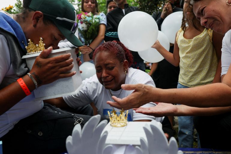 Zuleiry Martinez, sister of Ashley Martinez, 29, and aunt of Kalani Martinez, 2, who were killed in the June 24 earthquakes, kisses her sister's ashes before burying them, as her other sister, Caidelys, reacts beside her at Tarmas cemetery, in La Guaira, Venezuela, July 15, 2026. REUTERS/Pablo Sanhueza TPX IMAGES OF THE DAY