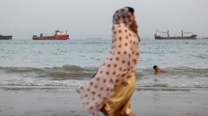 FILE PHOTO: People walk on the beach, with vessels in the Strait of Hormuz visible near the beach of Bandar Abbas, Iran, May 22, 2026. Majid Asgaripour/WANA (West Asia News Agency) via REUTERS ATTENTION EDITORS - THIS PICTURE WAS PROVIDED BY A THIRD PARTY/File Photo